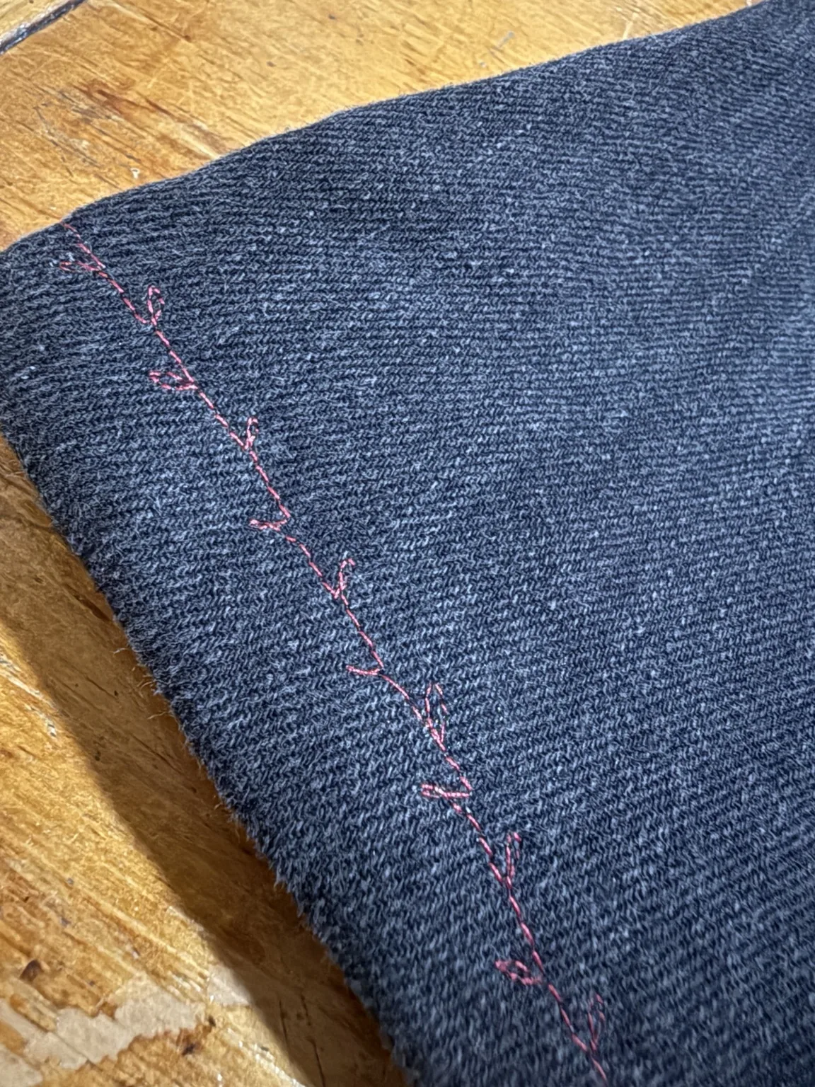Hand stitching along reconstructed denim seam