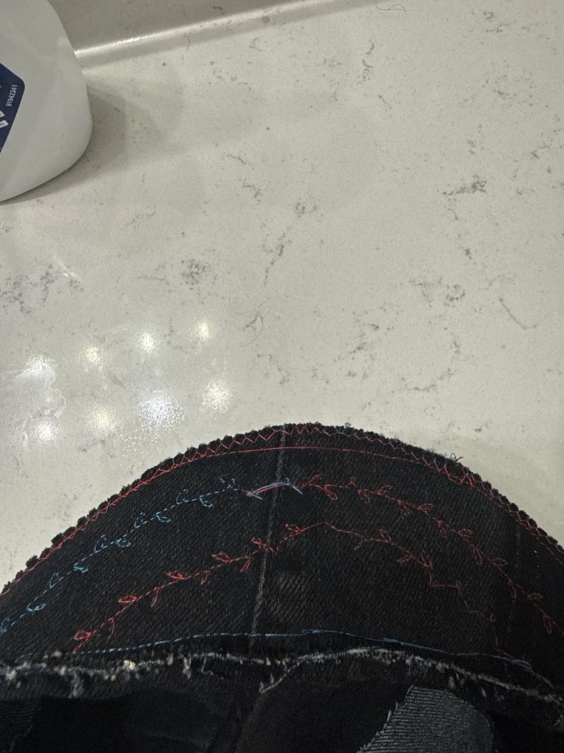 Red and blue contrast stitching along handmade cap